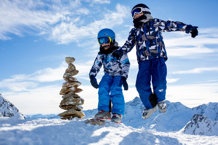 Happy people, children and adults, skiing on a sunny day in Tyrol mountains. Kids having fun while skiingの写真素材