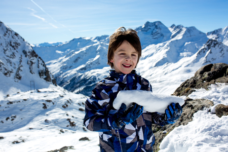 Happy people, children and adults, skiing on a sunny day in Tyrol mountains. Kids having fun while skiingの写真素材