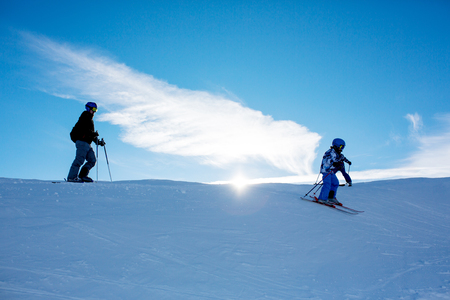 Happy people, children and adults, skiing on a sunny day in Tyrol mountains. Kids having fun while skiingの写真素材