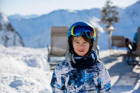 Happy people, children and adults, skiing on a sunny day in Tyrol mountains. Kids having fun while skiingの写真素材