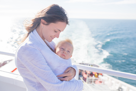 Happy family, traveling on vacation on board of cruise, outdoor on the deck, summertimeの写真素材