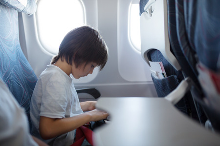 Little baby boy, playing with toys on board of the aircraft, happy travelerの写真素材