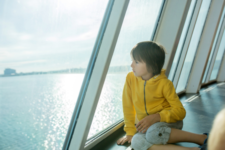 Beautiful children, on board on ferry boat, traveling for a vacation summertimeの写真素材