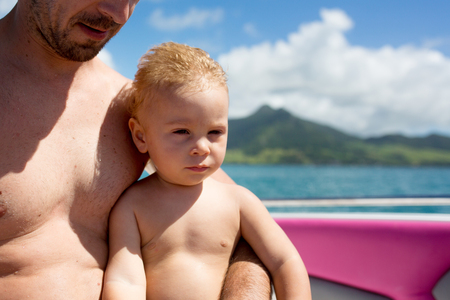 Happy beautiful fashion family, children and parents, dressed in hawaiian shirts, enjoying day trip with speed boat in Mauritiusの写真素材