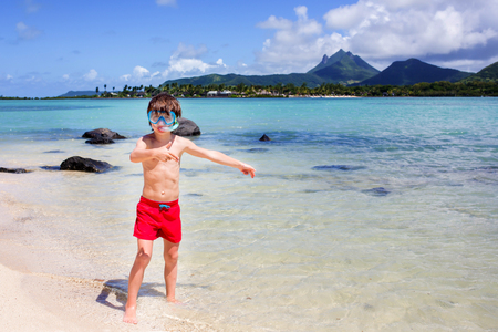 Child snorkeling on tropical beach. Kids snorkel in ocean on family summer vacation on exotic island. Little boy playing with water and sand at sea shore. Toddler running in waves. Beach fun for kidの写真素材