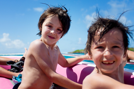 Happy beautiful family, children and parents, dressed in beach wear, enjoying day trip with speed boat in Mauritiusの写真素材