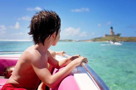 Happy beautiful family, children and parents, dressed in beach wear, enjoying day trip with speed boat in Mauritiusの写真素材
