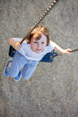 Child swinging on the playground  springtimeの写真素材