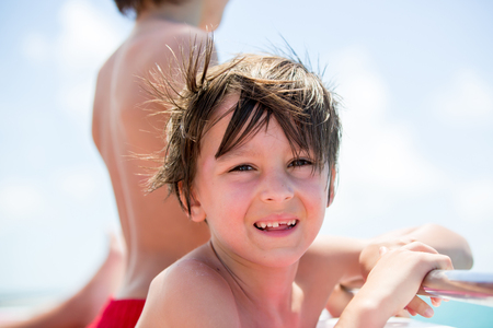 Happy beautiful fashion family, children and parents, dressed in hawaiian shirts, enjoying day trip with speed boat in Mauritiusの写真素材