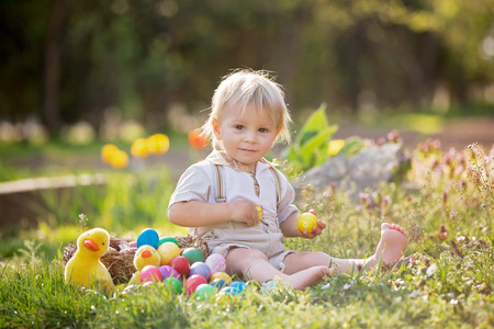 Sweet toddler boy, egg hunting for Easter, child and Easter day traditions. Kids and holidays