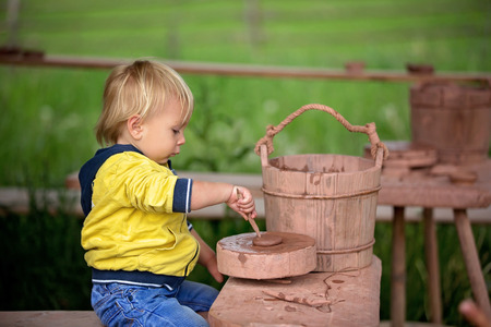Child, cute boy, making ceramic pot on a farmの写真素材