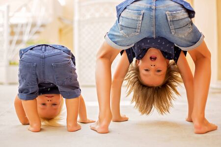 Child standing upside down, smiling happily while having funの写真素材