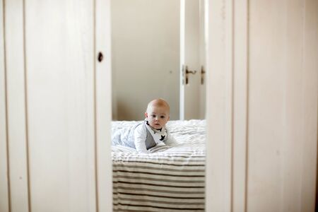 Little baby boy, sleeping in big bed in bedroom in the afternoon