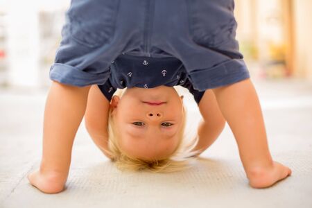 Child standing upside down, smiling happily while having fun