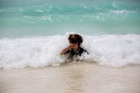 Adorable preschool children, boys, having fun on ocean beach. Excited children playing with waves,...