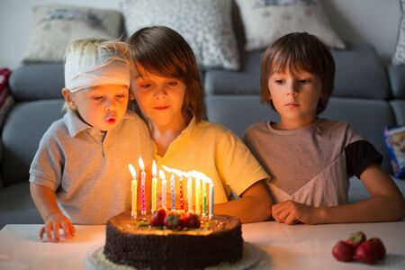 Beautiful boy and his two brothers, celebrating his tenth birthday at home with homemade chocolate...