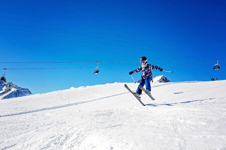 Happy people, children and adults, skiing on a sunny day in Tyrol mountains. Kids having fun while skiingの写真素材