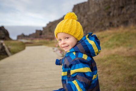Cute child, boy enjoying the beautiful landscape view of Thingvellir national park, Iceland...