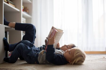 Cute child, boy, reading a book at home, happy to learnの写真素材