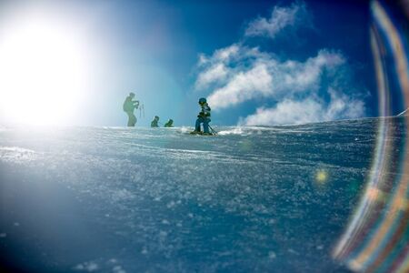 Happy people, children and adults, skiing on a sunny day in Tyrol mountains. Kids having fun while skiingの写真素材