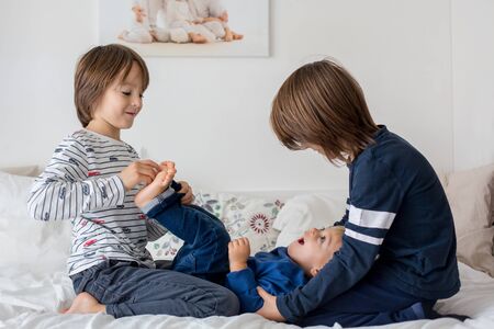 Children, brothers, playing at home, tickling feet laughing and smiling