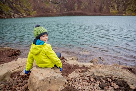 Children, boys, posing in front of Kerid crater lake in Iceland, autumntimeの写真素材