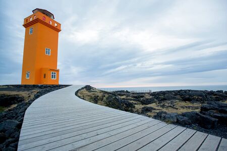 Lighthouse in lava field in beautiful nature in Snaefellsjokull National Park in Iceland, autumntime on sunsetの写真素材