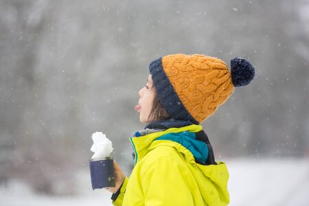 Sweet toddler boy, playing with snow on playground, kid play with snowの写真素材
