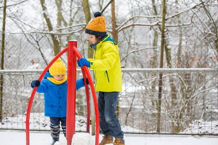 Sweet toddler boy, playing with snow on playground, kid play with snowの写真素材