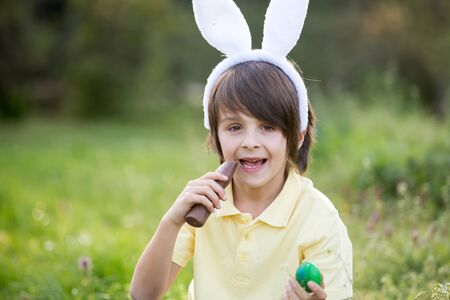 Sweet children, boy brothers with bunny ears, egg hunting for Easter, child and Easter day...