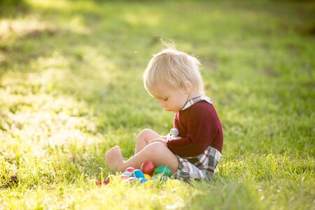Sweet toddler boy, egg hunting for Easter, child and Easter day traditions. Kids and holidays