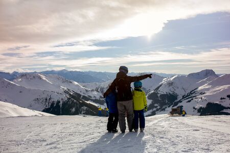 Family, skiing in winter ski resort on a sunny day, enjoying scenery landscapeの写真素材
