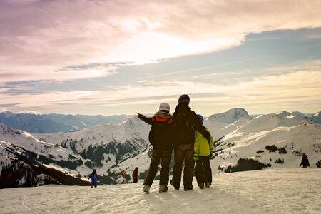 Family, skiing in winter ski resort on a sunny day, enjoying scenery landscapeの写真素材