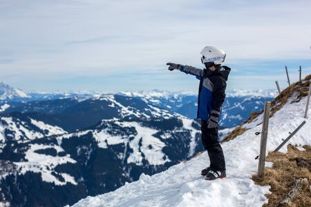 Child in winter ski resort on a sunny day, enjoying scenery landscape