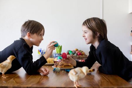 Two children, boy brothers, fighting at home with easter eggs in the morning in Easter dayの写真素材