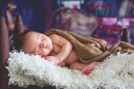 Little newborn baby boy, sleeping in wooden baby bed with little chick, sweet animal friendの写真素材