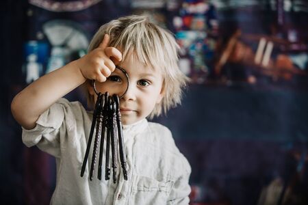 Toddler child, holding old vintage keys and bouquet of wild flowers in little vaseの写真素材