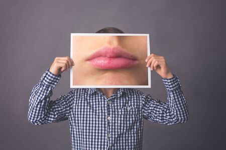 Child, boy, showing different emotions, isoalted shot on gray backgroundの写真素材
