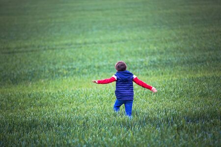 Pretenn children, boys, running in green field on a cloudy day, childhood happinessの写真素材