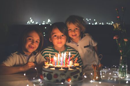 Sweet child, celevrating his birhtday with homemade birthday cake with lots of chocolate on top,...