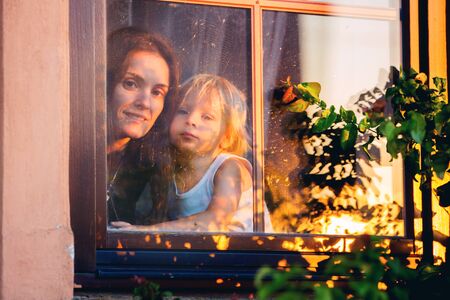 Child, toddler boy, looking through window outsideの写真素材