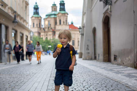 Cute child, boy, visiting Prague after the quarantine Covid 19, eating ice cream, empty streetsの写真素材
