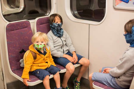 Child, boy, wearing protective mask in underground. Sit in subway in Prague, wearing maskの写真素材