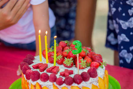 Sweet little blond toddler boy, celebrating his third birthday in a park, outdoorsの写真素材