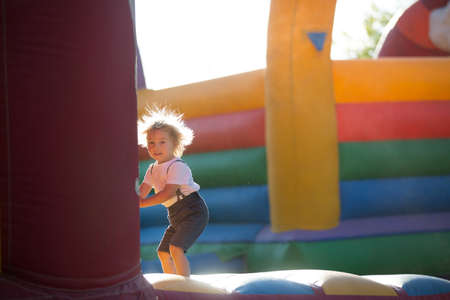 Children, boys, playing jumping on colorful trampoline in parkの写真素材