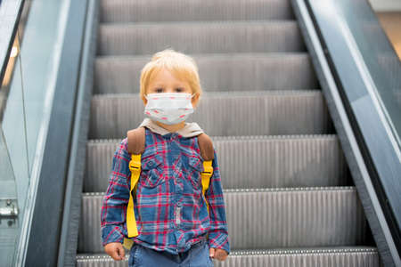Toddler child, boy, wearing protective medical mask in shopping center during coronavirus Covid 19 pandemicの写真素材