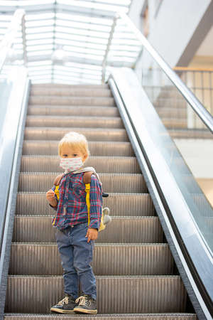 Toddler child, boy, wearing protective medical mask in shopping center during coronavirus Covid 19 pandemicの写真素材