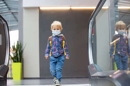 Toddler child, boy, wearing protective medical mask in shopping center during coronavirus Covid 19...