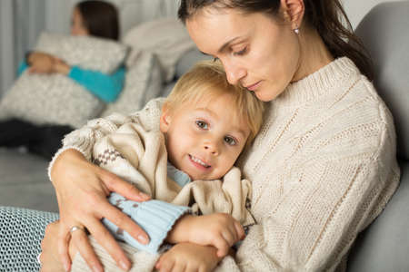 Mother and child, blond boy, lying on the couch at home, huggingの写真素材