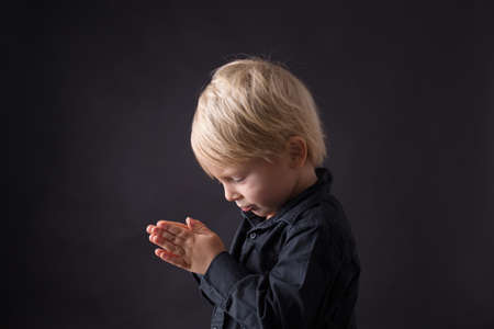 Little toddler child, boy praying, child praying, isolated backgroundの写真素材